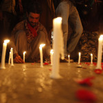 A man lights candles to mourn the victims from the Army Public School in Peshawar, which was attack by Taliban gunmen, in Karachi