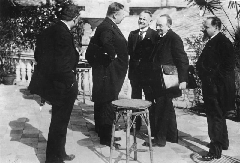 1922: German Chancellor Joseph Wirth (second from left) and Soviet Foreign minister Georgi Chicherin, sign the diplomatic and economic agreement that puts an end to the isolation of the two countries after World War I.